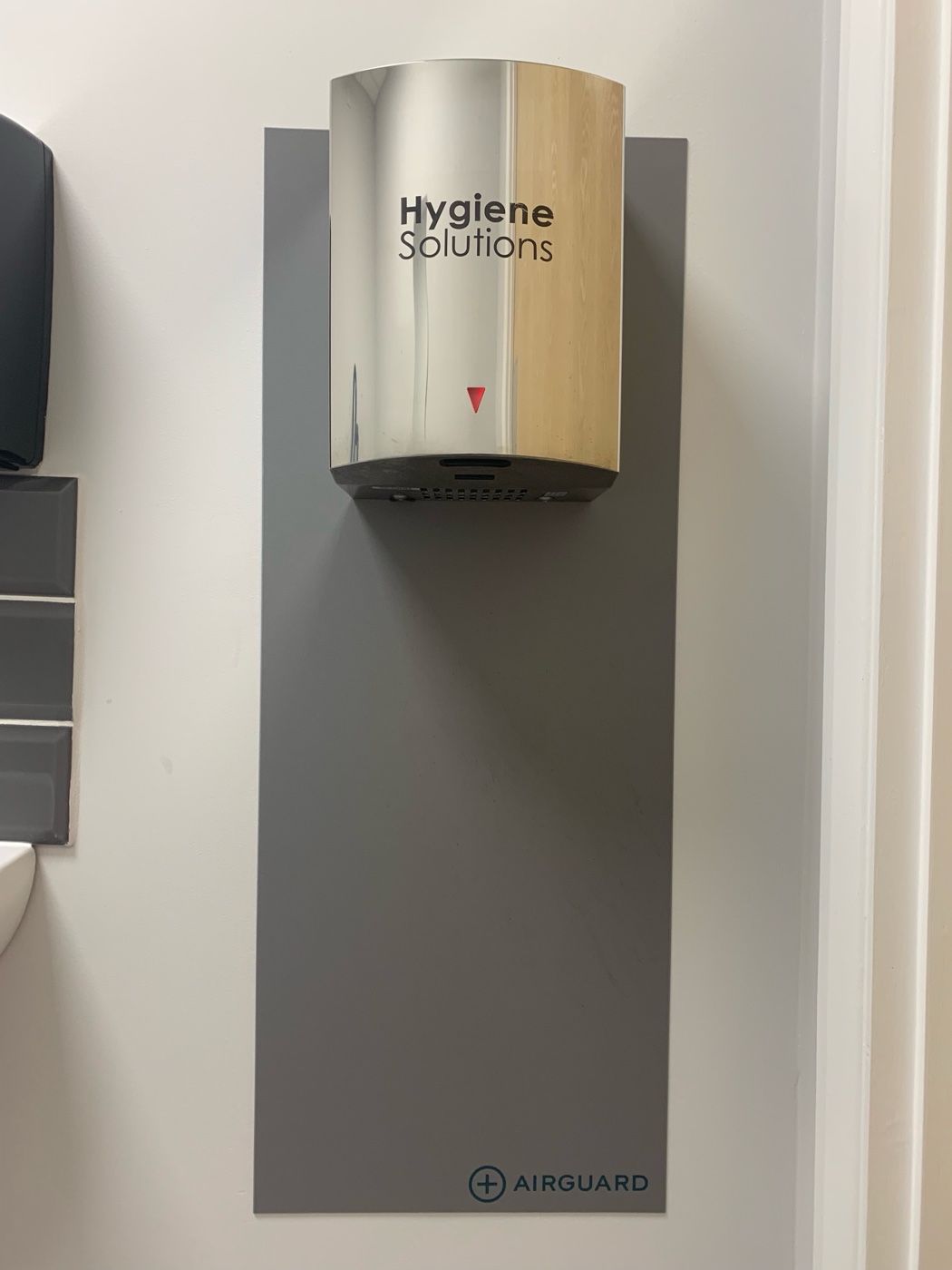 Chrome Speed Force hand dryer installed on an AirGuard backplate in a washroom